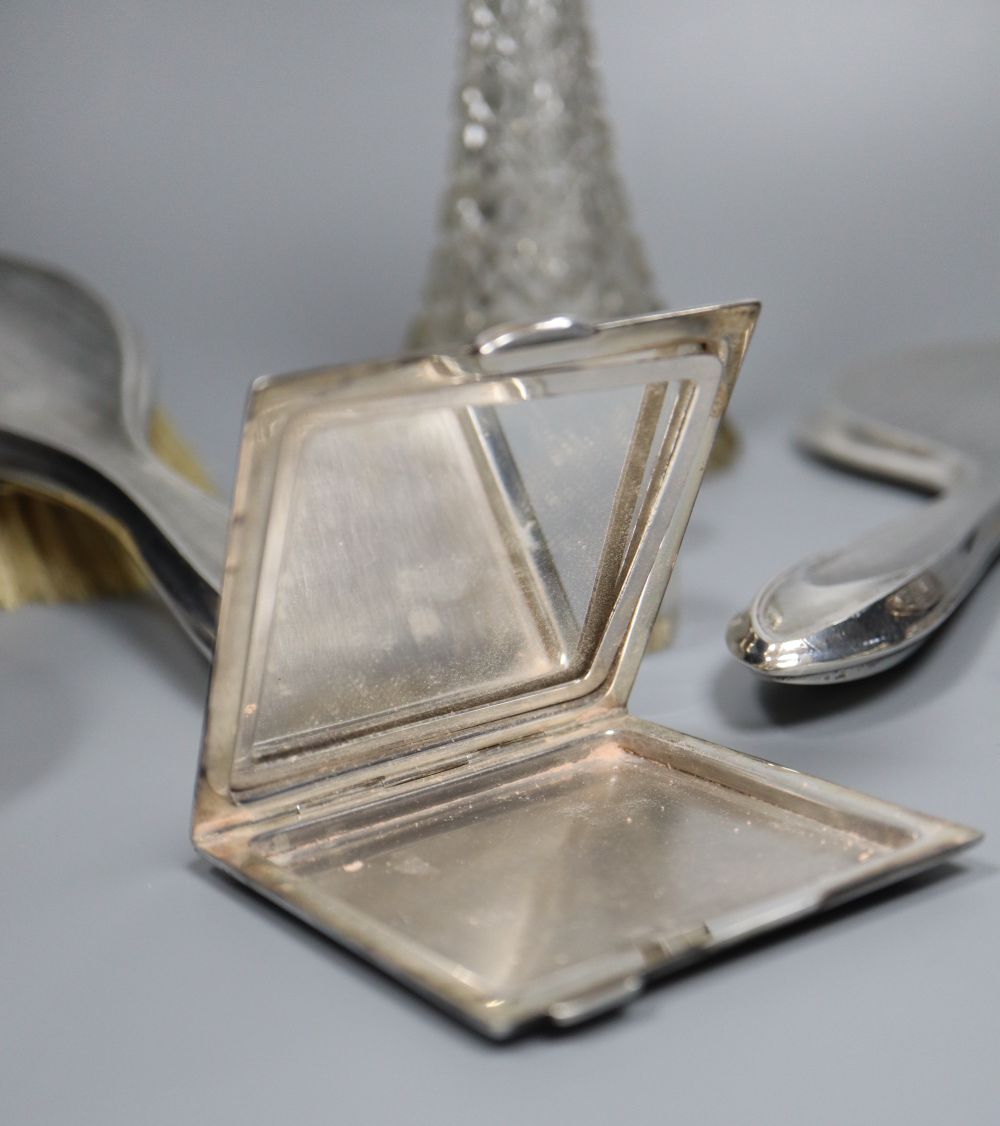 A silver-mounted conical glass scent bottle, sundry other silver-mounted toilet items and an engine-turned silver compact.